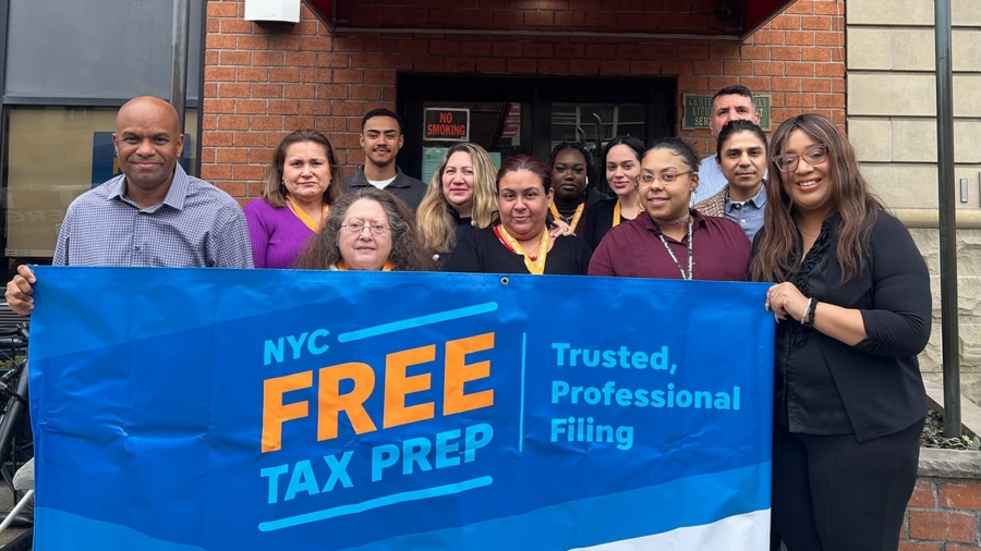 New York City tax team hold "free tax prep" sign.