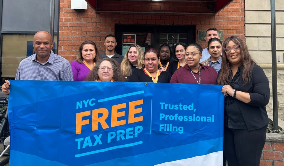 New York City tax team hold "free tax prep" sign.